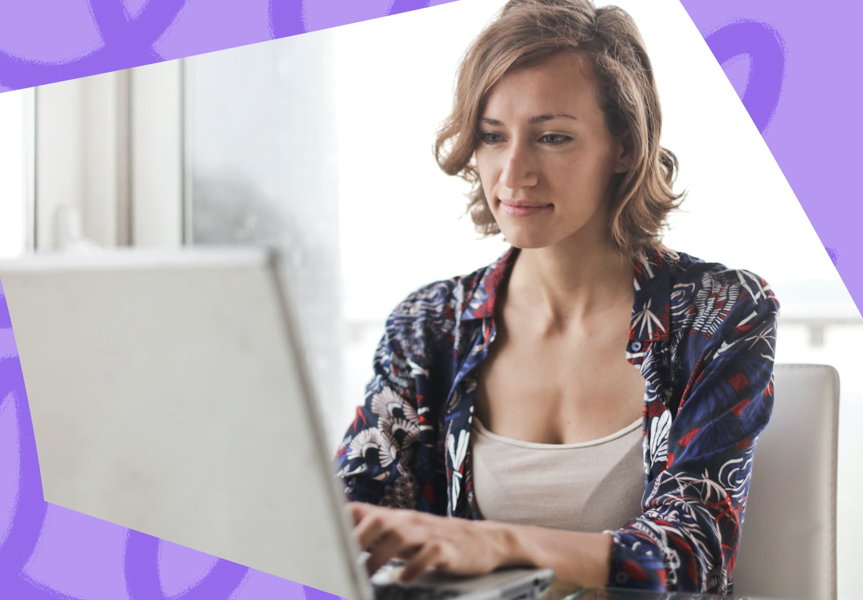 Smiling woman sitting in front of a laptop