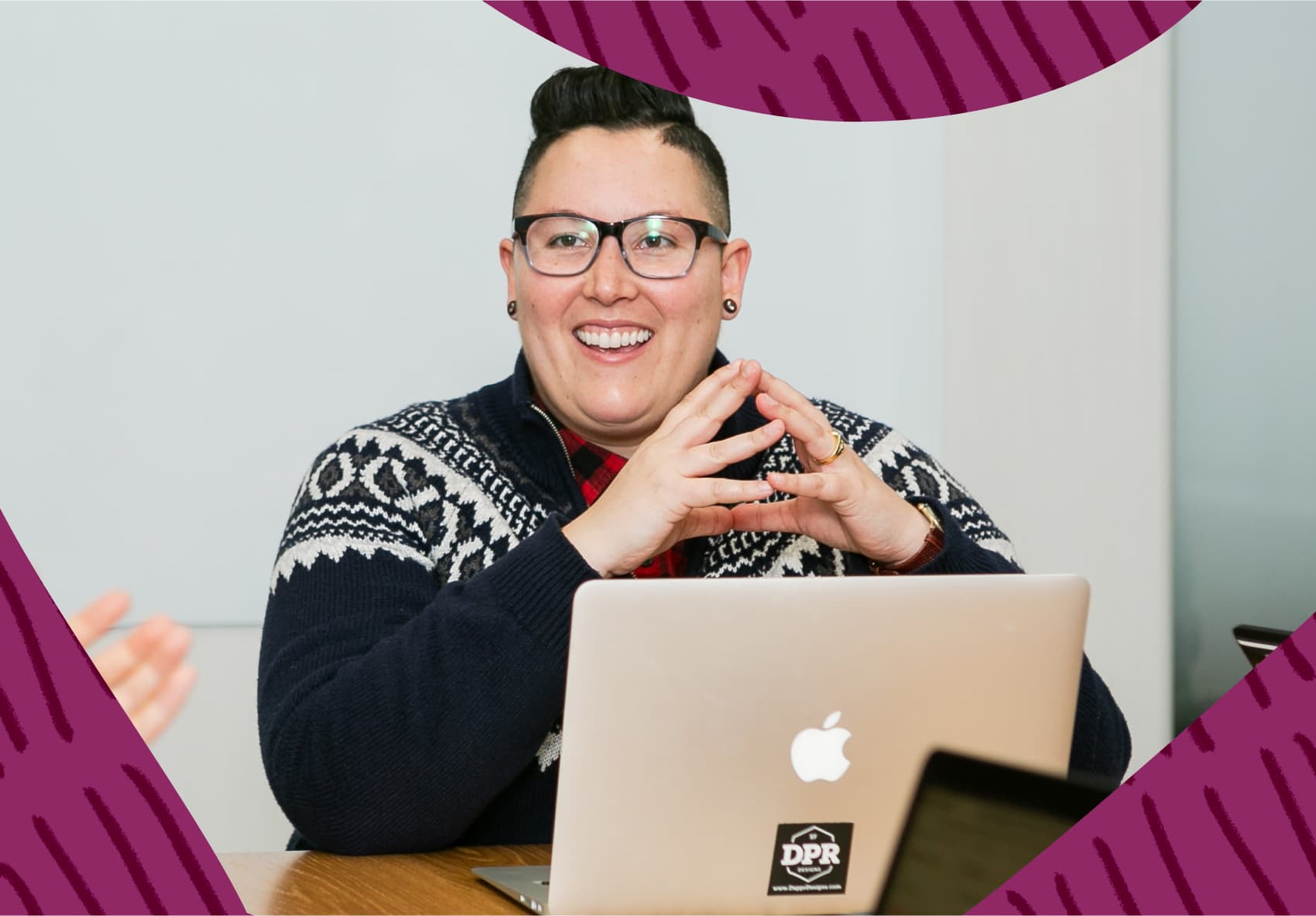 Smiling person sitting in front of a laptop
