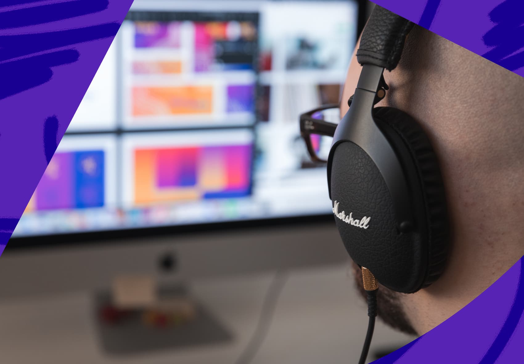 Man with headphones on looking at computer screen