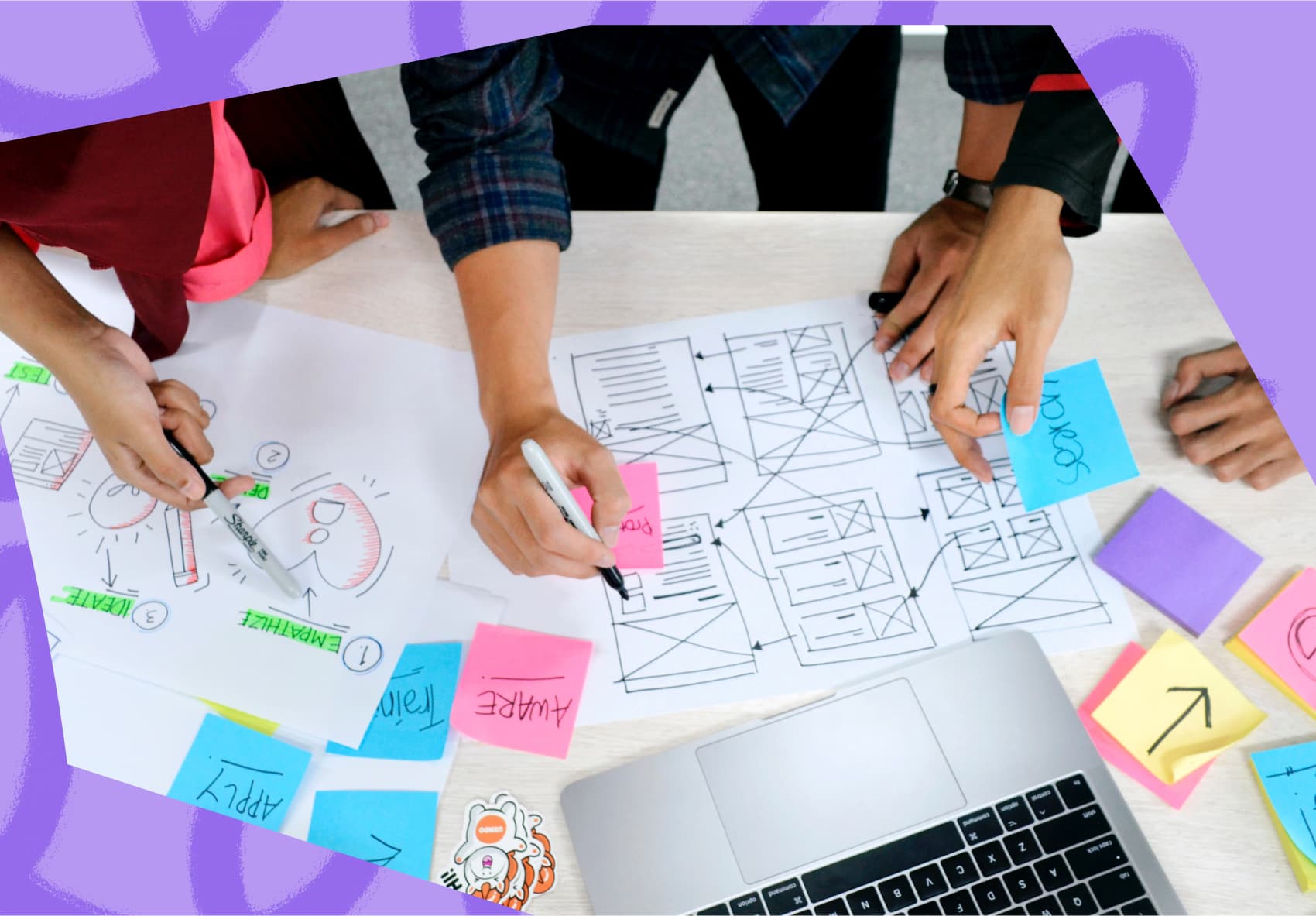 Design sprint showing three people looking at wireframe prototypes and writing post-it notes