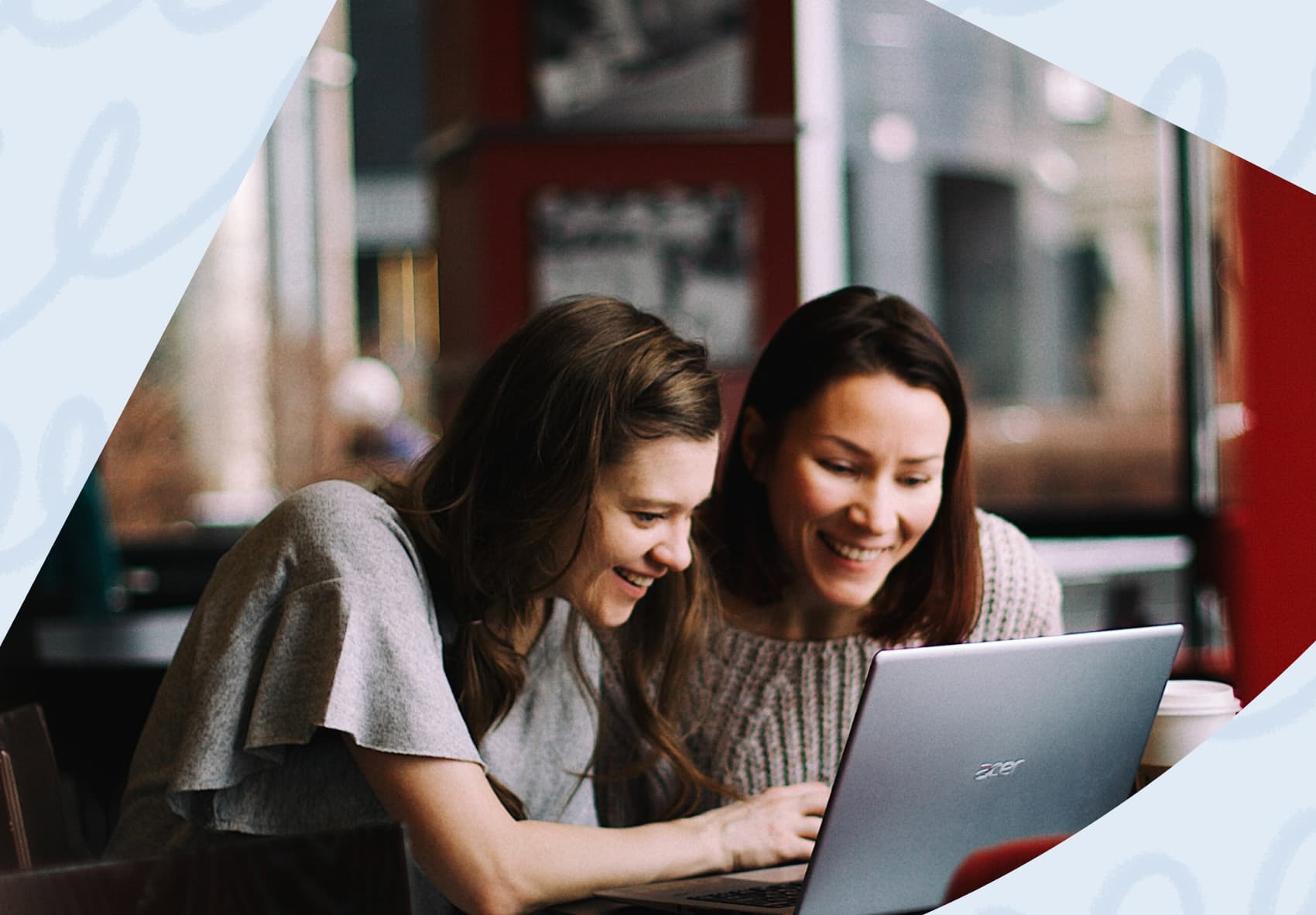 Two women sitting in front of a laptop at work
